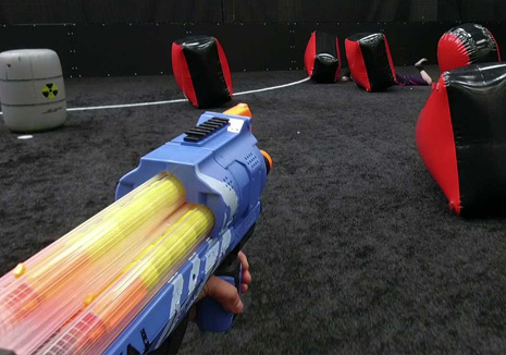 a kid shooting balls using yellow nerf war gun